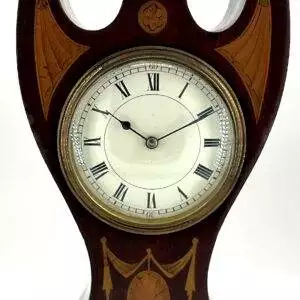 Exquisite Edwardian mahogany case Mantel clock with inlaid decoration and top brass finial, circa 1900s. Unusual art nouveau inspired shape.