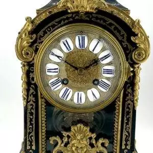 Stunning French boulle bracket clock. Original ormolu dial with enamel roman numerals. The case has brass decoration inlay and scrolls finials on the edges and topped with an ormolu floral basket finial. Also has a viewing window to see the starburst pendulum in action.