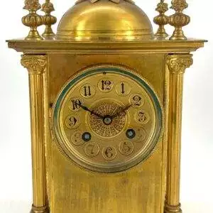 Lovely Victorian French mantle clock with bronze ormolu case. The Case is of architectural design with 2 flanking Corinthian pillars and 4 corner finials and a domed top all finished in ormolu.